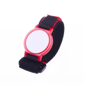 Una pulsera RFID de 125 kHz con una carcasa de plástico roja y un espacio en blanco., cara blanca circular, todo asegurado con una correa ajustable negra.