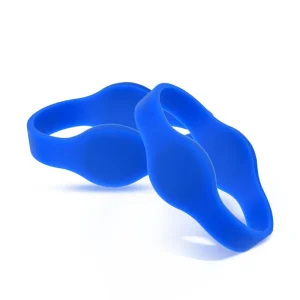 Dos anillos de silicona de color azul con diseño ondulado., parte del sistema de pulsera RFID, superponerse sobre un fondo blanco.