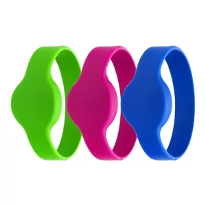 Երեք Proximity Wristbands, հասանելի է կանաչ, վարդագույն, և կապույտ, ցուցադրվում են անընդմեջ. Յուրաքանչյուր սիլիկոնե ձեռքի ժապավեն ցուցադրում է ալիքաձև դիզայն կենտրոնում.