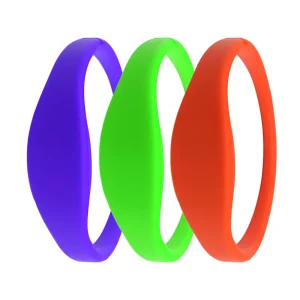 Três pulseiras com chip RFID são exibidas em uma fileira, colorido roxo, verde, e vermelho da esquerda para a direita.