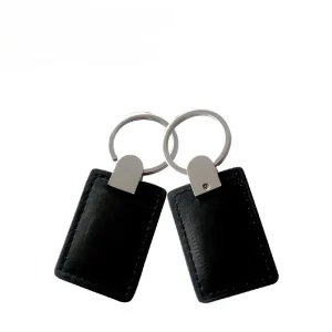 The Leather key fob for RFID (2) conjunt, featuring two black leather key fobs with rectangular tags attached to metal rings, is displayed against a plain white background.