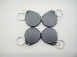 Upat ka Dual Frequency Key Fobs nga adunay metal key rings, matag usa sa abohon, giorganisar sa usa ka duha-sa-duha nga grid sa usa ka puti nga nawong.