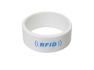 Fehér RFID karszalag kék szöveggel: "Festival RFID Solutions" kék jelzőikonokkal a szöveg mindkét oldalán, célja a fesztivál RFID megoldásainak javítása.