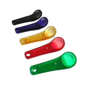 Five translucent plastic measuring spoons from the Ibutton RFID collection, each equipped with an RFID tag and available in black, blau, groc, vermell, i colors verds, are arranged in a row.