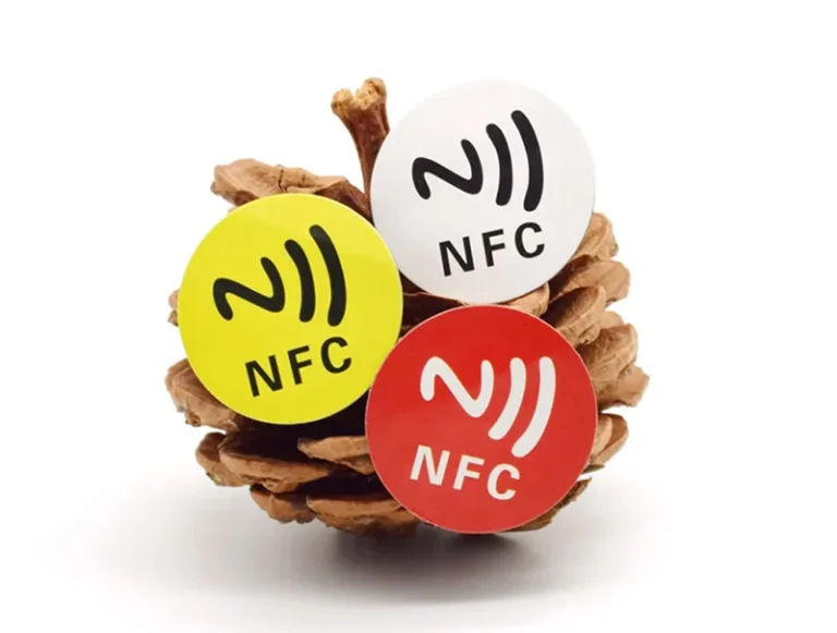 Tres NFC Labels in flavo, album, et rubra sunt appensa in pinecone.