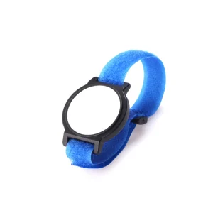 Um relógio chique com mostrador em branco e pulseira de tecido azul, uma reminiscência da pulseira de tecido RFID personalizada, colocado contra um fundo branco imaculado.