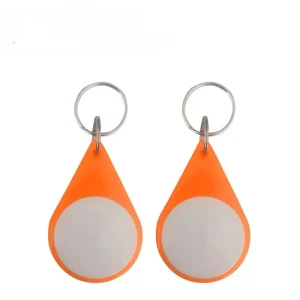 Duha ka rfid key fobs (1) sa usa ka orange nga teardrop nga porma, nga nagpakita sa puti nga lingin nga mga sentro ug metal nga yawe singsing nga gilakip sa ibabaw.