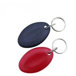 rfid key fob luam (1) khoom set, uas suav nrog ob lub oval-zoo li tus yuam sij fobs - ib qho dub thiab ib qho liab - txhua qhov nruab nrog RFID cim npe thiab txuas nrog lub nplhaib nyiaj., yog tso tawm tawm tsam ib tug dawb dawb tom qab.