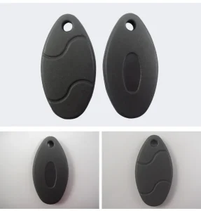 Zwei schwarz, Oval geformte Kunststoffschlüsselfobs mit einem kleinen Loch an einem Ende. Das obere Bild zeigt beide Seiten der FOBS zusammen, während die unteren Bilder jede Seite einzeln aufweisen. Ideal für die Verwendung mit einem RFID -Schlüssel -FOB -Duplikator (1).