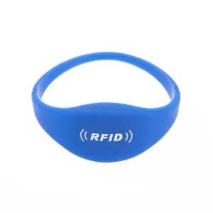 蓝色 RFID 标签手环，正面饰有白色 RFID 标志和信号图标, 以白色背景为背景. 这款优雅的配件与其他 RFID 标签手环无缝集成, 兼具时尚感和安全性.