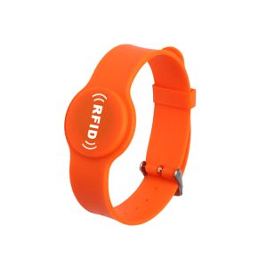 Wrist Band For Access Control is a bright orange RFID wristband featuring an adjustable lorum cum fibula rectangula. Fronte textui immiscetur "(RFID)" in albis.